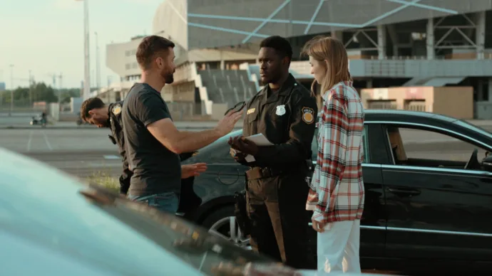 Young couple talking to a police officer representing the communication and open information needed for community safety