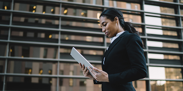 Lawyer walking and looking down at a tablet device