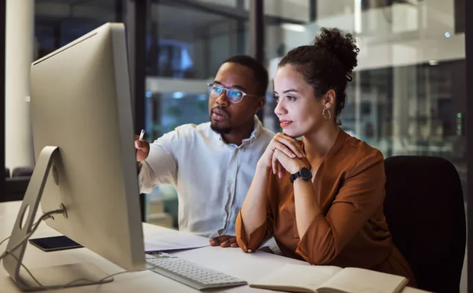 Two legal professionals working together at a computer.