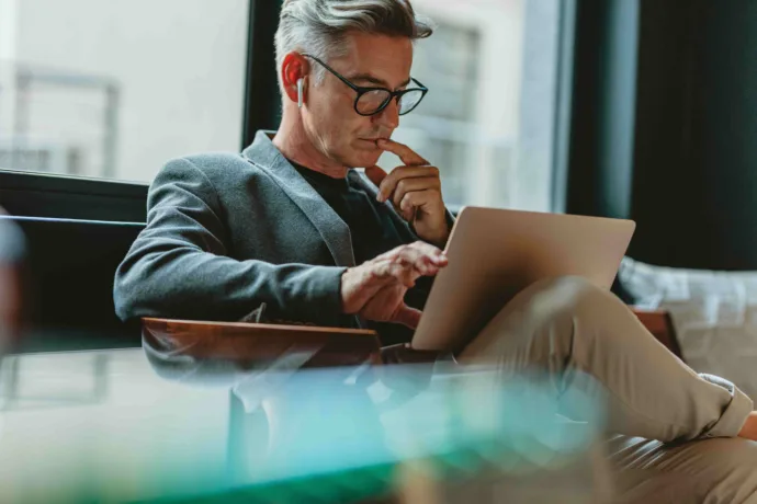 white haired man business man working at a laptop