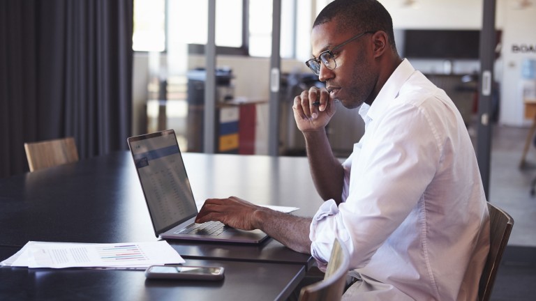 man-wearing-glasses-using-laptop-office