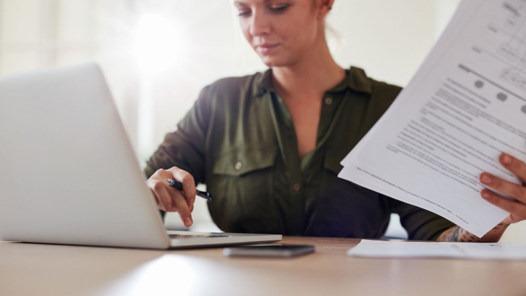 woman-table-documents-working-laptop