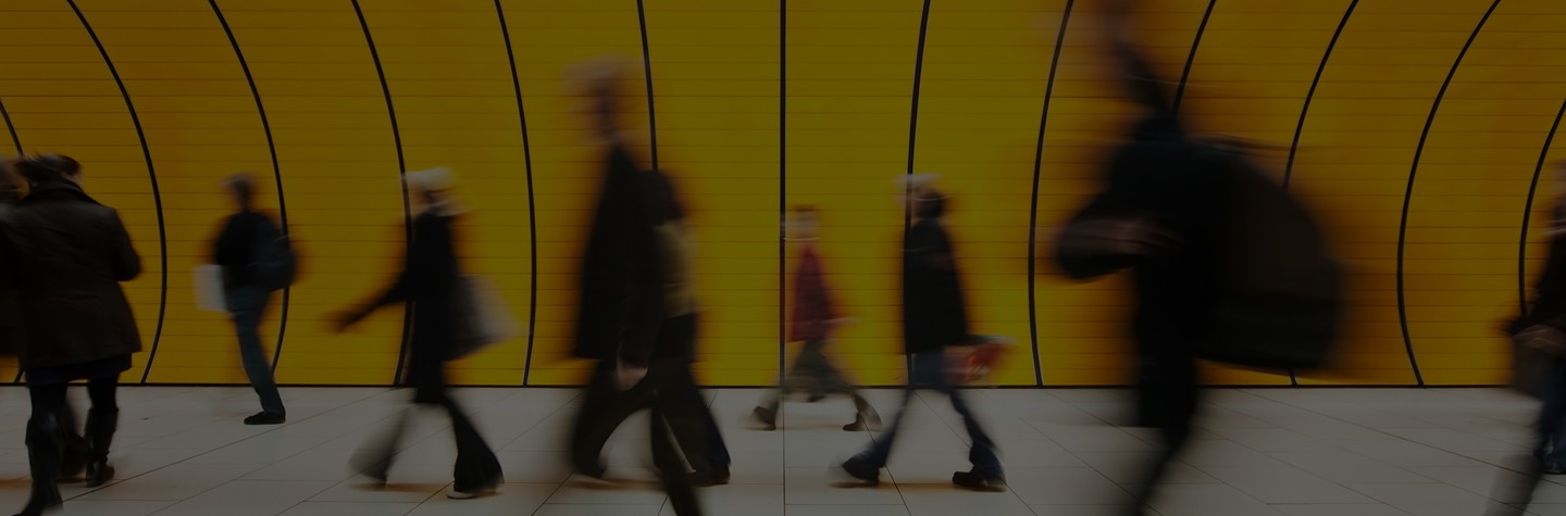 blurred and defocused people walking in orange subway