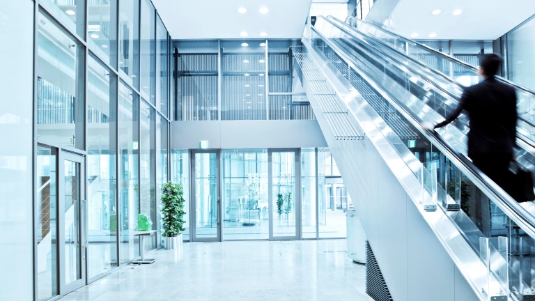 Business man walking up a escalator, Blurred Motion