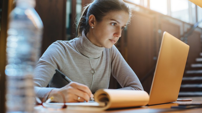 Portrait of young business woman using laptop at library